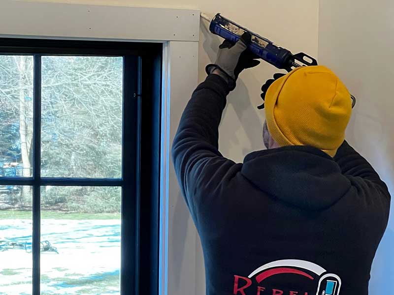 Close up of a Rebel Exteriors Inc. crew sealing up the frame around a new window installation