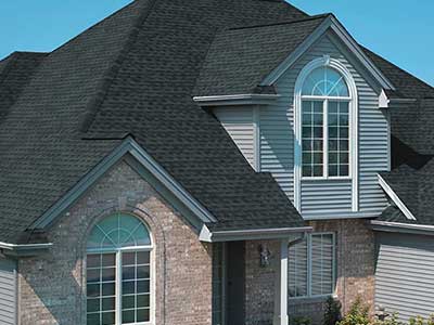 Front view of a two-story, mid-class home with black GAF shingles on its roof
