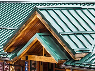 Front view of a commercial building with a sloped, green metal roof